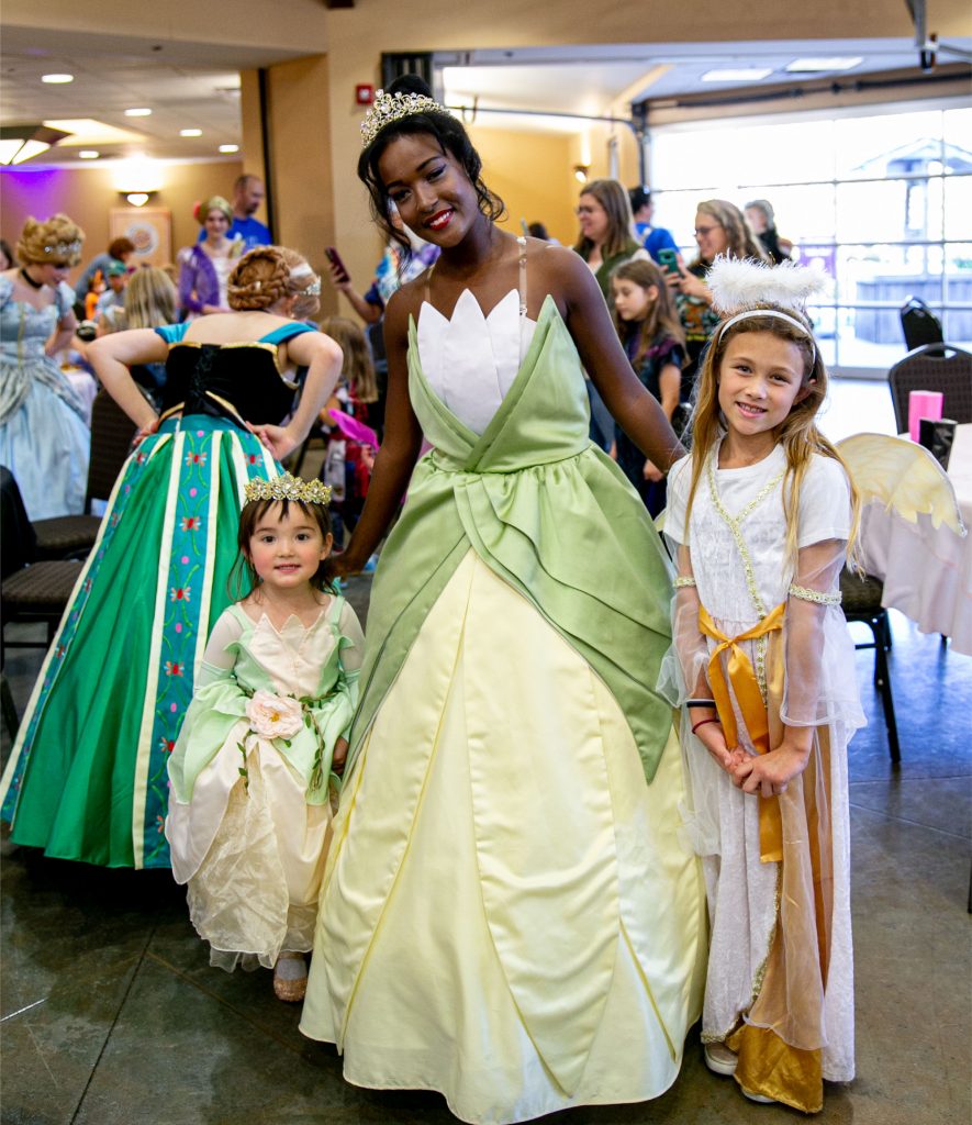 a woman dressed like a princess with two young girls